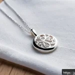 은 목걸이 변색 방지 방법 - A delicate sterling silver necklace resting on a soft, light-colored microfiber cloth, glistening un...
