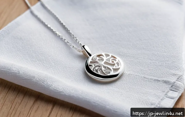 은 목걸이 변색 방지 방법 - A delicate sterling silver necklace resting on a soft, light-colored microfiber cloth, glistening un...