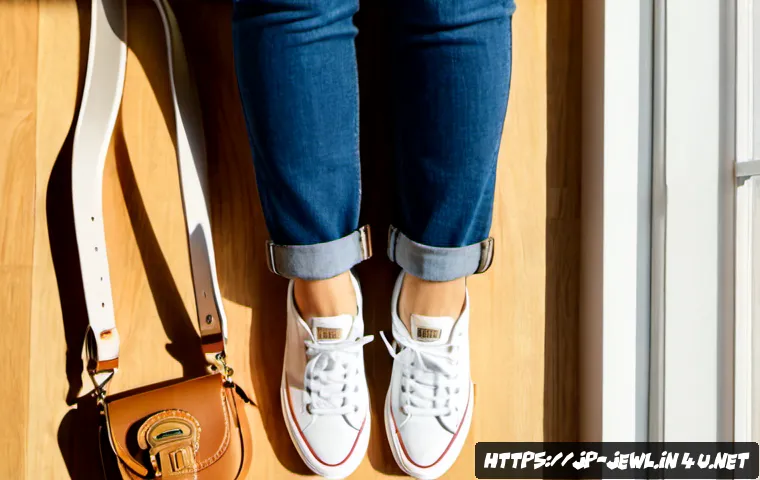 청바지와 어울리는 액세서리 추천 - Photorealistic flat lay of classic blue denim jeans paired with a tan leather belt, minimalist silve...